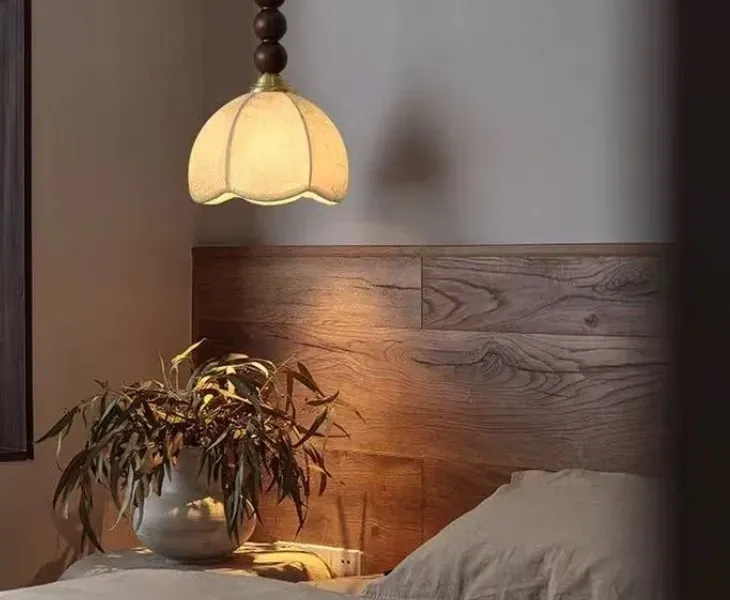 Pendant light hanging beside a bed as bedside lighting
